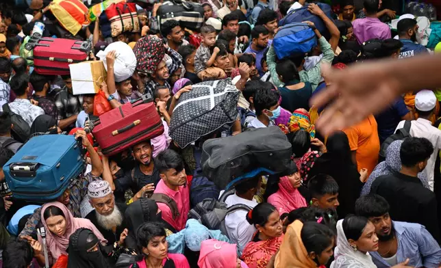 Thousands of travelers scramble and jostle each other to board ferries at the Sadarghat Launch Terminal, joining the massive annual exodus to celebrate Eid al-Fitr in their hometowns, in Dhaka, Bangladesh, Wednesday, March 18, 2026. (AP Photo/Mahmud Hossain Opu)