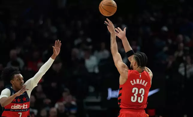 Portland Trail Blazers forward Toumani Camara (33) shoots a 3-pointer over Washington Wizards guard Bub Carrington (7) during the first half of an NBA basketball game Sunday, March 29, 2026, in Portland, Ore. (AP Photo/Jenny Kane)