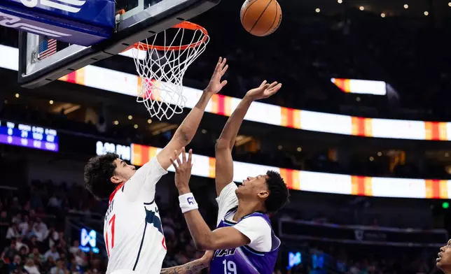 Washington Wizards forward Will Riley, left, defends Utah Jazz forward Ace Bailey (19) as he shoots during the second half of an NBA basketball game, Wednesday, March 25, 2026, in Salt Lake City. (AP Photo/Anna Fuder)