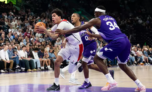 Utah Jazz forward Oscar Tshiebwe (34) and Utah Jazz forward Kennedy Chandler (0) defend Washington Wizards forward Will Riley, left, during the first half of an NBA basketball game, Wednesday, March 25, 2026, in Salt Lake City. (AP Photo/Anna Fuder)