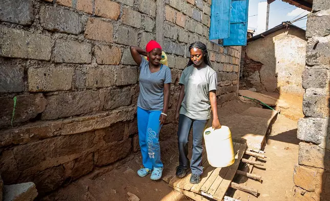 Women walk through the alleys of the Kibera informal settlement to fetch water on the outskirts of Nairobi, Kenya, Feb. 12, 2026. (AP Photo/Atieno Muyuyi)