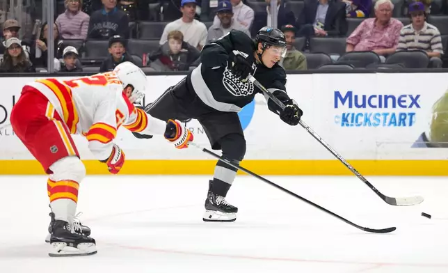 Los Angeles Kings left wing Trevor Moore, right, shoots against Calgary Flames defenseman MacKenzie Weegar during the second period of an NHL hockey game Saturday, Feb. 28, 2026 in Los Angeles. (AP Photo/Ryan Sun)
