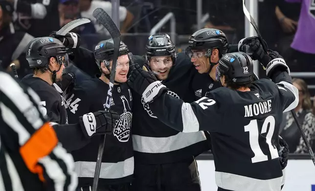 Los Angeles Kings right wing Alex Laferriere, center, celebrates with defenseman Cody Ceci, defenseman Mikey Anderson, right wing Quinton Byfield, and left wing Trevor Moore, from left, after scoring during the second period of an NHL hockey game against the Calgary Flames Saturday, Feb. 28, 2026 in Los Angeles. (AP Photo/Ryan Sun)