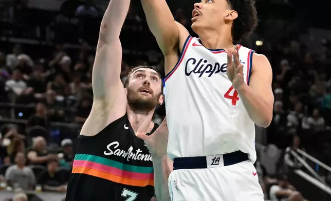 Los Angeles Clippers guard Kobe Sanders (4) goes to the basket against San Antonio Spurs center Luke Kornet (7) during the first half of an NBA basketball game, Friday, March 6, 2026, in San Antonio. (AP Photo/Darren Abate)