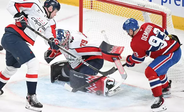 Washington Capitals goaltender Charlie Lindgren (79) stops Montreal Canadiens' Ivan Demidov (93) as Capitals' Aliaksei Protas (21) defends during the second period of an NHL hockey game in Montreal, Saturday, Feb. 28, 2026. (Graham Hughes/The Canadian Press via AP)