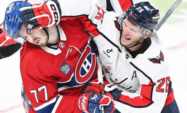 Washington Capitals' Nic Dowd (26) tries to face wash Montreal Canadiens' Kirby Dach (77) during the third period of an NHL hockey game in Montreal, Saturday, Feb. 28, 2026. (Graham Hughes/The Canadian Press via AP)