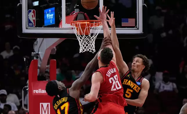 Atlanta Hawks forward Onyeka Okongwu (17) fouls Houston Rockets center Alperen Sengun (28) during the first half of an NBA basketball game in Houston, Friday, March 20, 2026. (AP Photo/Ashley Landis)