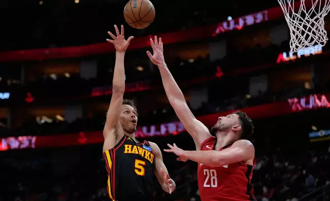 Atlanta Hawks guard CJ McCollum (3) shoots against Houston Rockets center Alperen Sengun (28) during the first half of an NBA basketball game in Houston, Friday, March 20, 2026. (AP Photo/Ashley Landis)