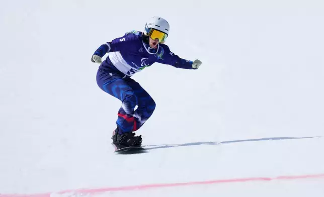 Cecile Hernandez, of France, approaches the finish line in her second run of the snowboard women's banked slalom sb-ll2 at the 2026 Winter Paralympics, in Cortina d'Ampezzo, Italy, Friday, March 13, 2026. (AP Photo/Evgeniy Maloletka)