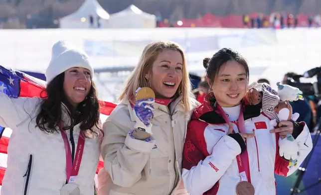Silver medalist Kate Delson, of the United States, from left, gold medalist Cecile Hernandez, of France, and bronze medalist Wang Xinyu, of China, pose after the women's snowboard cross SB-LL2 final at the 2026 Winter Paralympics, in Cortina d'Ampezzo, Italy, Sunday, March 8, 2026. (AP Photo/Evgeniy Maloletka