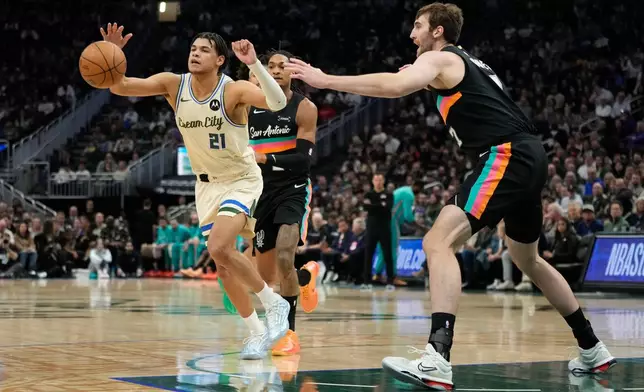 Milwaukee Bucks' Ousmane Dieng (21) controls the ball against San Antonio Spurs' Luke Kornet during the first half of an NBA basketball game Saturday, March 28, 2026, in Milwaukee. (AP Photo/Aaron Gash)