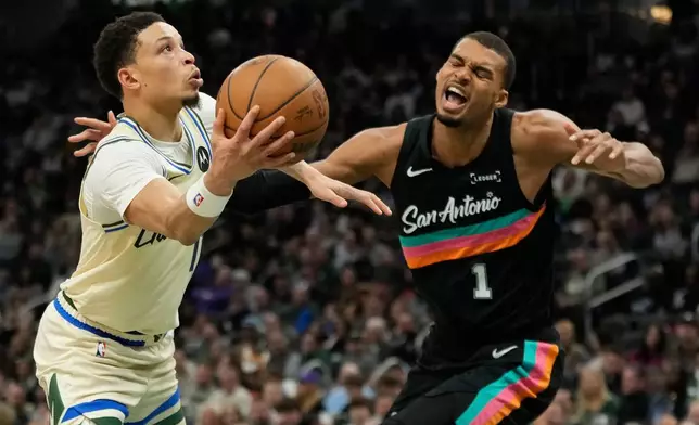Milwaukee Bucks' Ryan Rollins, left, shoots against San Antonio Spurs' Victor Wembanyama during the first half of an NBA basketball game Saturday, March 28, 2026, in Milwaukee. (AP Photo/Aaron Gash)