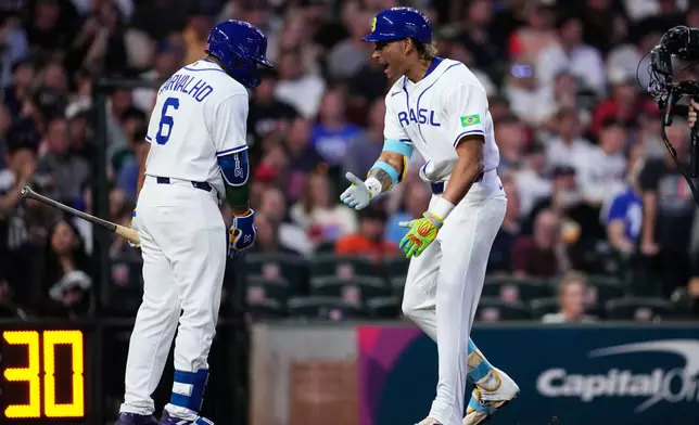 Brazil's Lucas Ramirez, right, celebrates with Osvaldo Carvalho after hitting a solo home run during the first inning of a World Baseball Classic game against the United States, Friday, March 6, 2026, in Houston. (AP Photo/Ashley Landis)