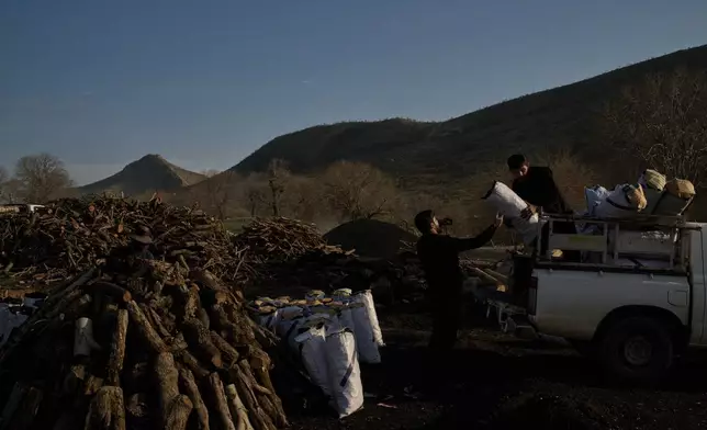 Workers load a vehicle with sacks of charcoal at a traditional production site in Sarkand, Iraq, Thursday, March 12, 2026. (AP Photo/Leo Correa)