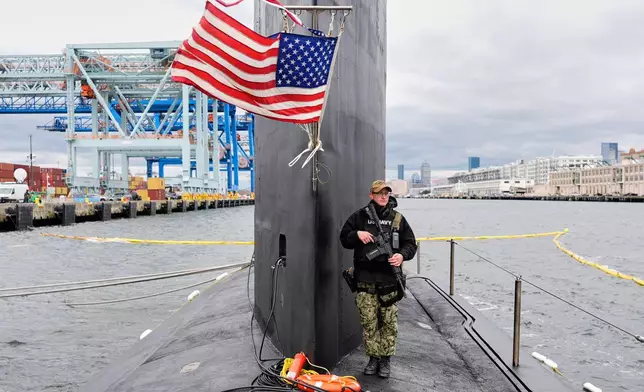 A sailor stands guard next to the sail of the USS Massachusetts, the Navy's newest nuclear-powered attack submarine, Friday, March 27, 2026, in Boston. (AP Photo/Robert F. Bukaty)