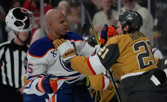 Vegas Golden Knights center Brett Howden (21) and Edmonton Oilers defenseman Darnell Nurse (25) fight during the first period of an NHL hockey game Thursday, March 26, 2026, in Las Vegas. (AP Photo/John Locher)