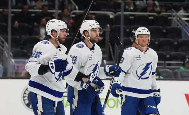 Tampa Bay Lightning right wing Nikita Kucherov, left, celebrates his goal with left wing Brandon Hageld, center, during the second period of an NHL hockey game against the Seattle Kraken, Tuesday, March 17, 2026, in Seattle. (AP Photo/Lindsey Wasson)