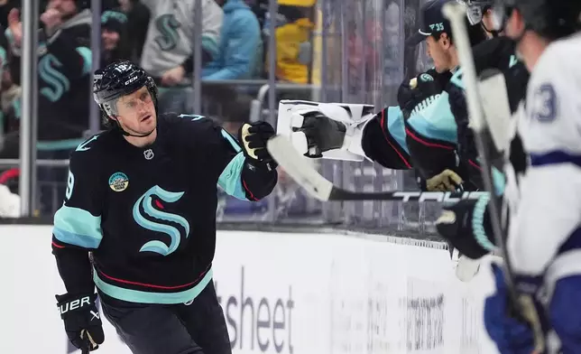 Seattle Kraken left wing Jared McCann celebrates his goal against the Tampa Bay Lightning with the bench during the second period of an NHL hockey game Tuesday, March 17, 2026, in Seattle. (AP Photo/Lindsey Wasson)