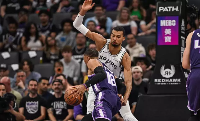 San Antonio Spurs forward Victor Wembanyama (1) defends Sacramento Kings guard Russell Westbrook (18) during the first half of an NBA basketball game, Tuesday, March 17, 2026, in Sacramento, Calif. (AP Photo/Justine Willard)