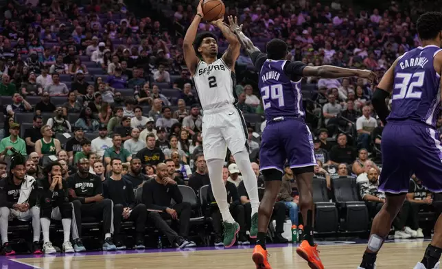 San Antonio Spurs guard Dylan Harper (2) shoots over Sacramento Kings guard Daeqwon Plowden (29) during the first half of an NBA basketball game, Tuesday, March 17, 2026, in Sacramento, Calif. (AP Photo/Justine Willard)