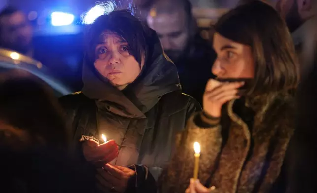Georgian believers hold candles in memory of Georgian Orthodox Patriarch Ilia II at the hospital where he died in Tbilisi, Georgia, on Tuesday, March 17, 2026. (AP Photo/Zurab Tsertsvadze)