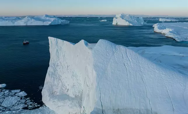A fishing boat pulls a net up with fish in front of an iceberg at Disko Bay near Ilulissat, Greenland, on Thursday, Jan. 29, 2026. (AP Photo/Evgeniy Maloletka)