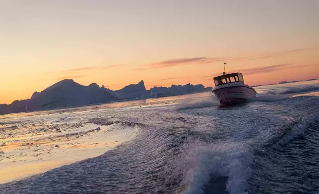 A fishing boat rides in front of an iceberg at Disko Bay near Ilulissat, Greenland, on Wednesday, Jan. 28, 2026. (AP Photo/Evgeniy Maloletka)