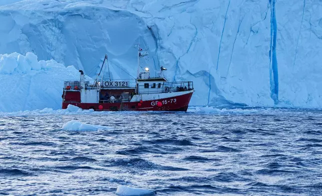 A fishing boat pulls a net up with fish in front of an iceberg at Disko Bay near Ilulissat, Greenland, on Thursday, Jan. 29, 2026. (AP Photo/Evgeniy Maloletka)