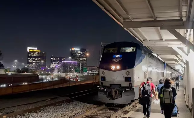 This image made from an Associated Press video shows passengers boarding the Amtrak Crescent headed towards New York on Thursday, March 26, 2026, in Atlanta. (AP Photo/Bill Barrow)