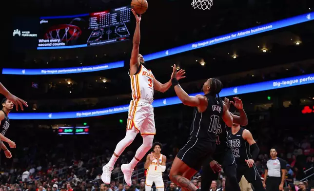 Atlanta Hawks guard CJ McCollum (3) shoots against Brooklyn Nets guard Tyson Etienne, right, during the first half of an NBA basketball game, Thursday, March 12, 2026, in Atlanta. (AP Photo/Colin Hubbard)