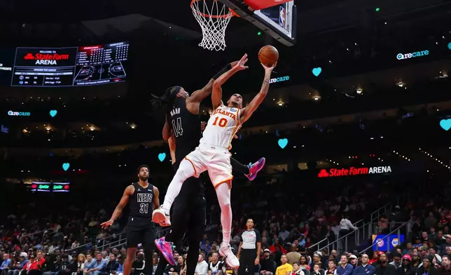 Atlanta Hawks forward Zaccharie Risacher (10) shoots against Brooklyn Nets guard Terance Mann (14) during the first half of an NBA basketball game, Thursday, March 12, 2026, in Atlanta. (AP Photo/Colin Hubbard)