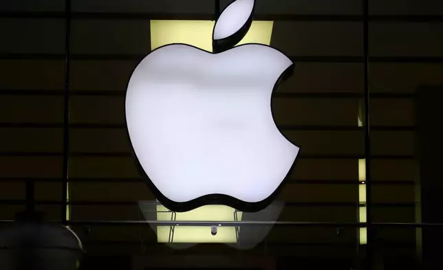 FILE - The logo of Apple is illuminated at a store in the city center in Munich, Germany, on Dec. 16, 2020. (AP Photo/Matthias Schrader, File)