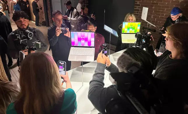 Members of the media view MacBook Neo laptop computers on display during an Apple unveil event, Wednesday, March 4, 2026, in New York (AP Photo/Ted Shaffrey) ,