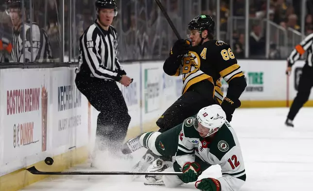 Minnesota Wild's Matt Boldy collides with Boston Bruins' David Pastrnak while going after a loose puck during the second period of an NHL hockey game Saturday, March 28, 2026, in Boston. (AP Photo/Winslow Townson)
