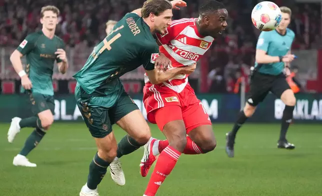 Bremen's Niklas Stark, left, and Union Berlin's Ilyas Ansah fight for the ball during the German Bundesliga soccer game between Union Berlin and Werder Bremen in Berlin, Germany, Sunday, March 8, 2026. (Soeren Stache/dpa via AP)