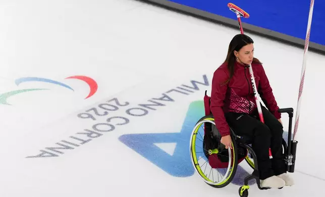 Polina Rozkova of Latvia, rides to the position during a wheelchair curling mixed doubles round robin session against Great Britain at the 2026 Winter Paralympics, in Cortina d'Ampezzo, Italy, Thursday, March 5, 2026. (AP Photo/Evgeniy Maloletka)