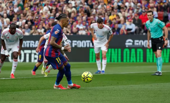 Barcelona's Raphinha scores on a penalty kick during the Spanish La Liga soccer match between Barcelona and Sevilla in Barcelona, Spain, Sunday, March 15, 2026. (AP Photo/Joan Monfort)