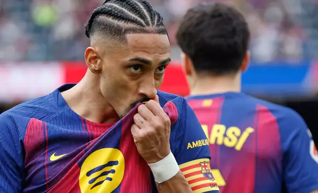 Barcelona's Raphinha celebrates after scoring his side's opening goal during the Spanish La Liga soccer match between Barcelona and Sevilla in Barcelona, Spain, Sunday, March 15, 2026. (AP Photo/Joan Monfort)
