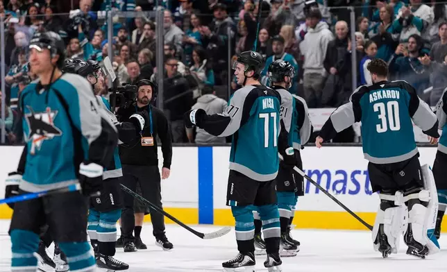 San Jose Sharks center Michael Misa (77) celebrates with teammates after scoring the game-winning goal during overtime of an NHL hockey game against the Winnipeg Jets, Sunday, March 1, 2026, in San Jose, Calif. (AP Photo/Godofredo A. Vásquez)