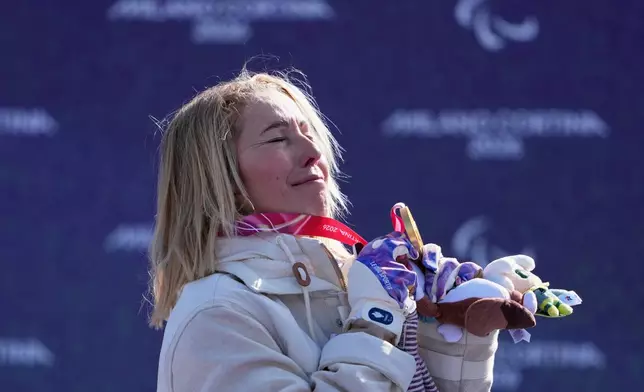 Cecile Hernandez, of France, stands on the podium after winning the gold medal in the women's snowboard cross SB-LL2 at the 2026 Winter Paralympics, in Cortina d'Ampezzo, Italy, Sunday, March 8, 2026. (AP Photo/Evgeniy Maloletka