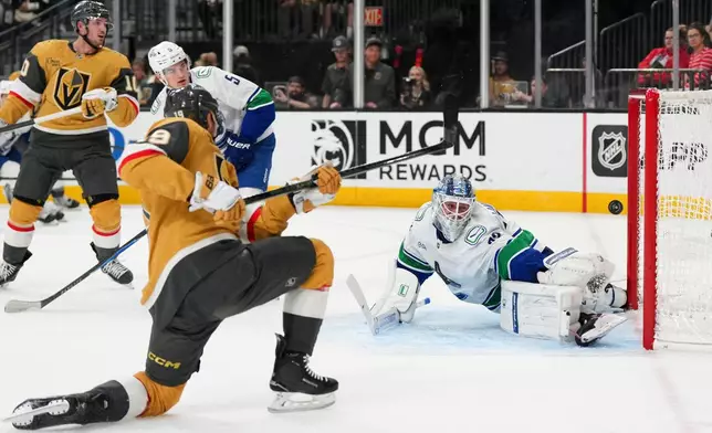 Vegas Golden Knights right wing Reilly Smith (19) scores against Vancouver Canucks goaltender Kevin Lankinen, right, during the second period of an NHL hockey game Monday, March 30, 2026, in Las Vegas. (AP Photo/Candice Ward)