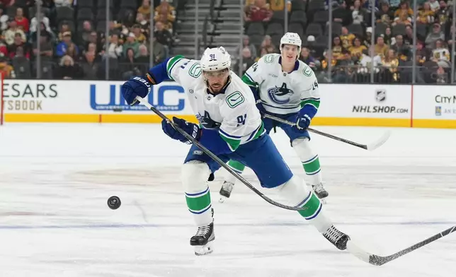 Vancouver Canucks left wing Evander Kane (91) chases after the puck against the Vegas Golden Knights during the first period of an NHL hockey game Monday, March 30, 2026, in Las Vegas. (AP Photo/Candice Ward)