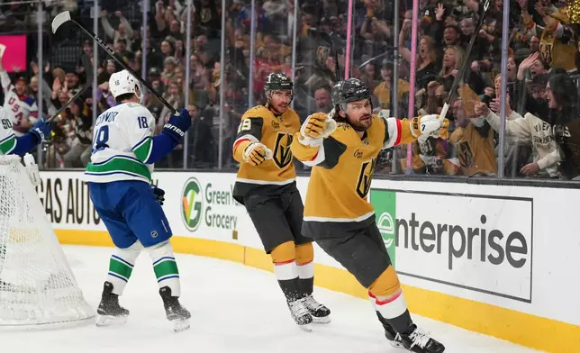 Vegas Golden Knights defenseman Rasmus Andersson, right, celebrates after his goal against the Vancouver Canucks during the second period of an NHL hockey game Monday, March 30, 2026, in Las Vegas. (AP Photo/Candice Ward)