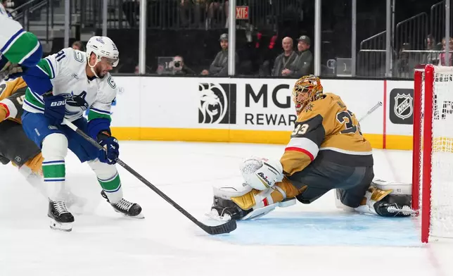 Vancouver Canucks left wing Evander Kane (91) scores against Vegas Golden Knights goaltender Adin Hill (33) during the first period of an NHL hockey game Monday, March 30, 2026, in Las Vegas. (AP Photo/Candice Ward)