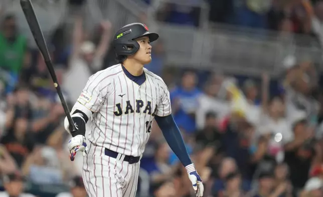 Japan's Shohei Ohtani hits a single home run during the first inning against Venezuela of a World Baseball Classic quarterfinal game, Saturday, March 14, 2026, in Miami. (AP Photo/Lynne Sladky)