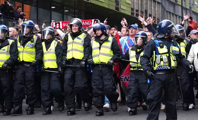 Police surround Sunderland fans ahead of the Premier League match between Newcastle and Sunderland outside St James' Park, Newcastle upon Tyne, England, Sunday March 22, 2026. (Owen Humphreys/PA via AP)