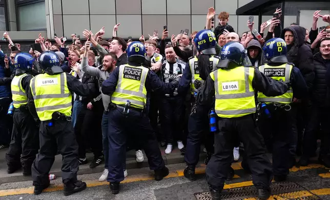 Police attempt to control Newcastle United fans ahead of the Premier League match between Newcastle and Sunderland outside St James' Park, Newcastle upon Tyne, England, Sunday March 22, 2026. (Owen Humphreys/PA via AP)