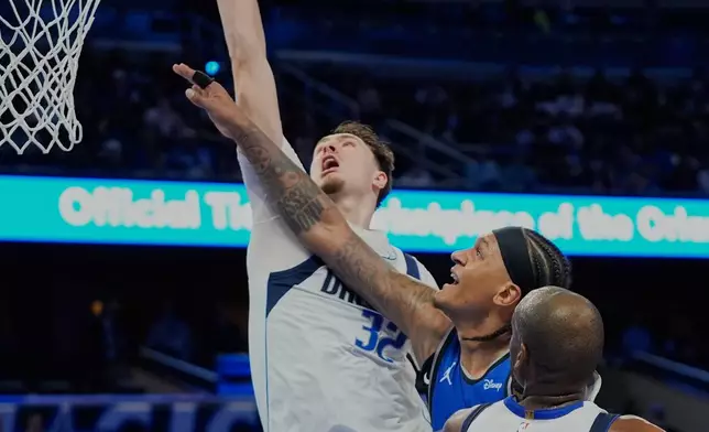 Dallas Mavericks forward Cooper Flagg, left, blocks a shot by Orlando Magic forward Paolo Banchero during the second half of an NBA basketball game, Thursday, March 5, 2026, in Orlando, Fla. (AP Photo/John Raoux)