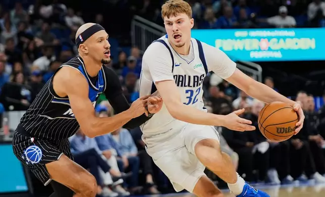 Dallas Mavericks forward Cooper Flagg (32) drives past Orlando Magic guard Jalen Suggs, left, during the first half of an NBA basketball game, Thursday, March 5, 2026, in Orlando, Fla. (AP Photo/John Raoux)