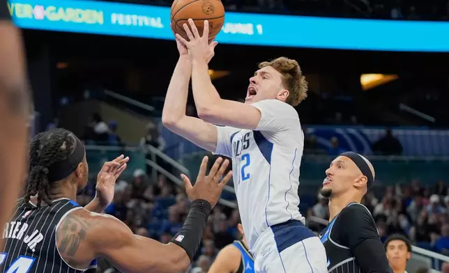 Dallas Mavericks forward Cooper Flagg, center, shoots over Orlando Magic center Wendell Carter Jr., left, and guard Jalen Suggs during the first half of an NBA basketball game, Thursday, March 5, 2026, in Orlando, Fla. (AP Photo/John Raoux)